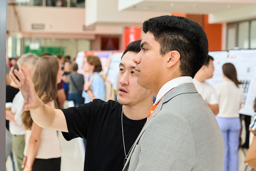 Student talking with other person about their work 