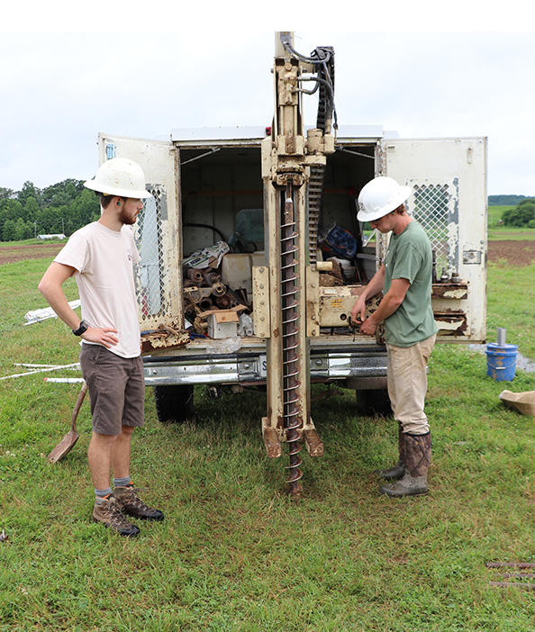 Two students with Geoprobe at the back of truck