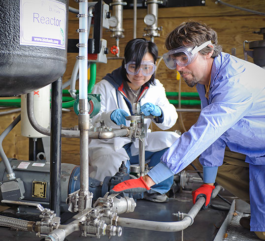 Faculty and student using lab equipment to create biofuel.