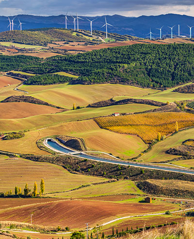 Field in Spain with turbines in the background.