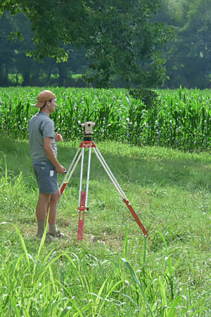 Male student outside in field with equipment.