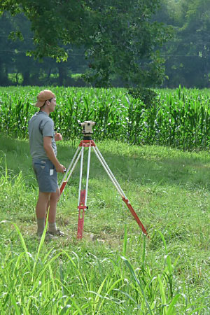Male student outside in field with equipment.