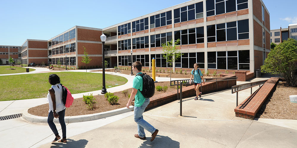 Exterior view of Martin Hall with students walking across campus in front of it.