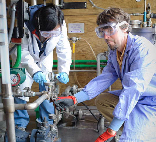 Walker with female student in biofuel area.