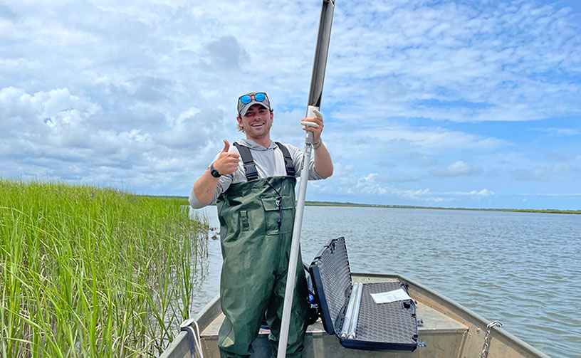 Student studying watershed research along the coast.