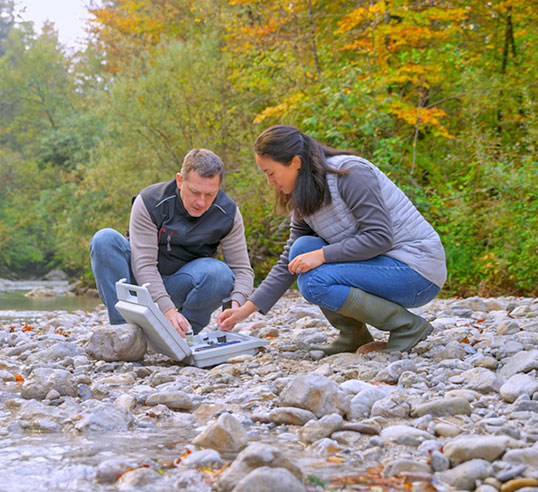 Female and male scientists measuring water quality