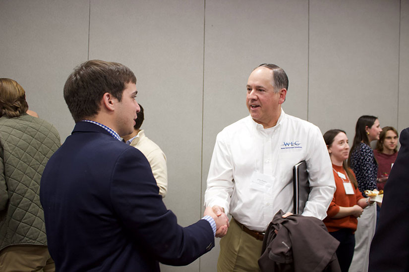 Student shaking hands and talking with an industry member