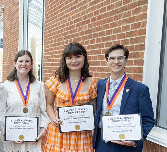 Students standing holding their awards