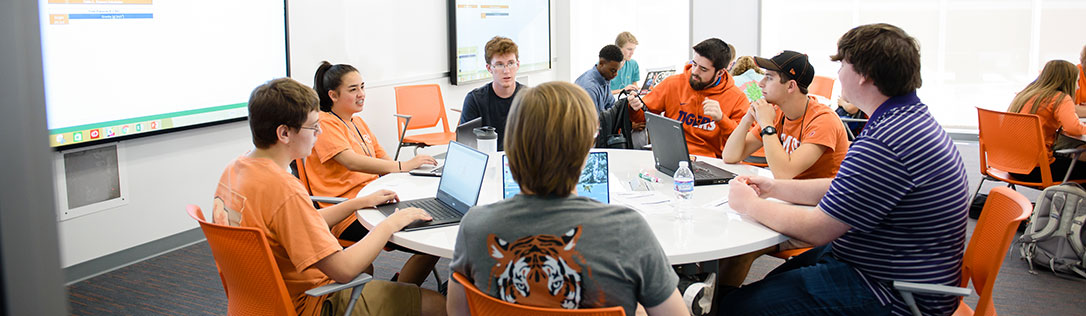 Several students in class working on laptops together
