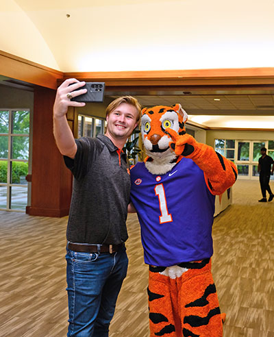 Student poses with tiger mascot.