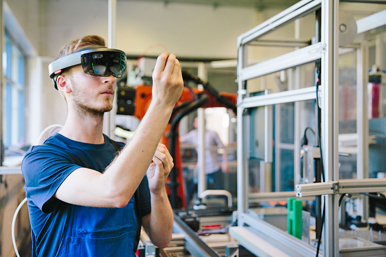 Male in makerspace with VR glasses on.