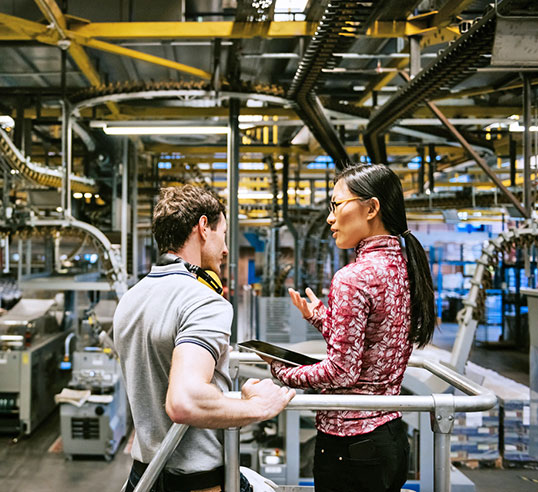 Employees talking while on manufacturing floor.