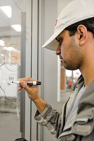 Male student in Watts using glass panes to plan.