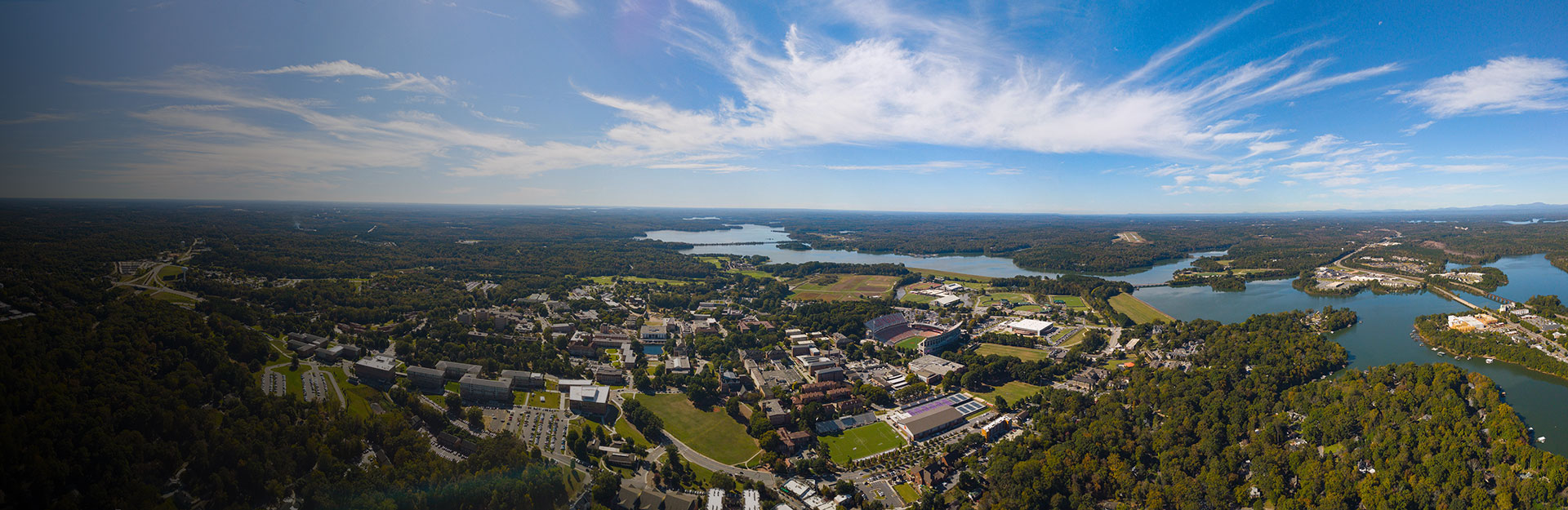 Aerial view of the Clemson University campus, overlooking, trees, buildings, and Lake Hartwell.