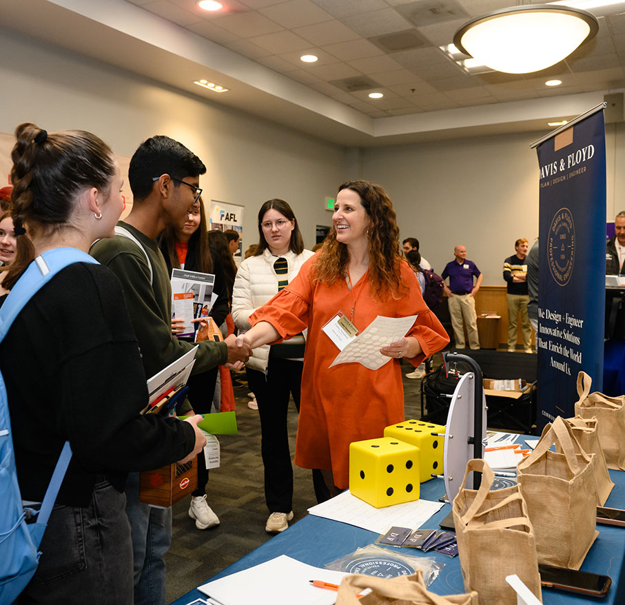 Career fair industry member shaking hands with a student.