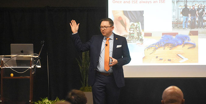 Presenter at IISE Conference, wearing tiger paw emblem lapel on jacket.