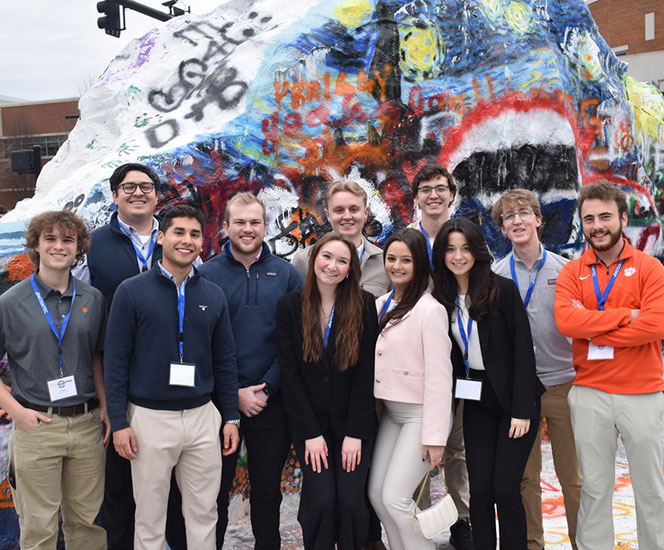 IISE students at TN campus beside large rock with graffiti