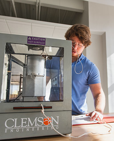 Student with machine in design lab.