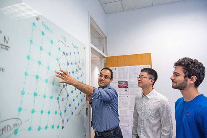 Abdeljawad with students at whiteboard.