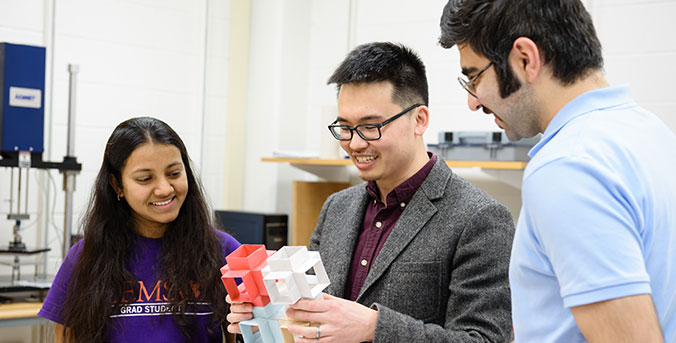 Faculty member and 2 students observing comb-like material.