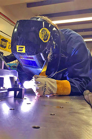 Student working on formula sae5 in shop.