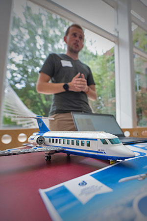 ME event with student in front of model airplane.
