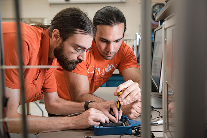 Faculty and graduate student working on project in lab.