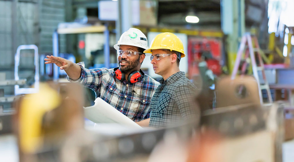 Two employees on floor of plant.