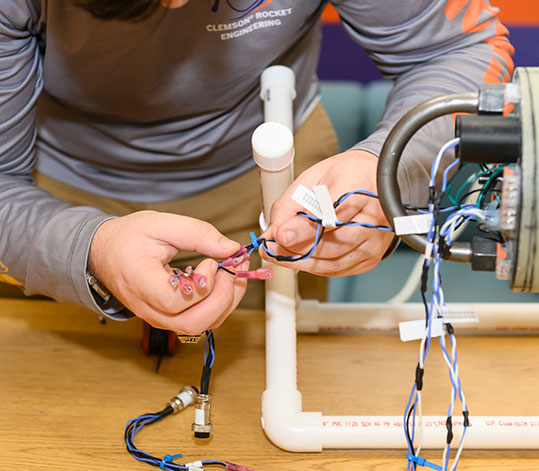 Student working on wires for the Rocket Engineering Club