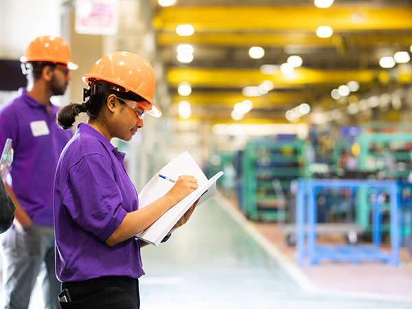 Student taking observation notes in local plant with global reach.