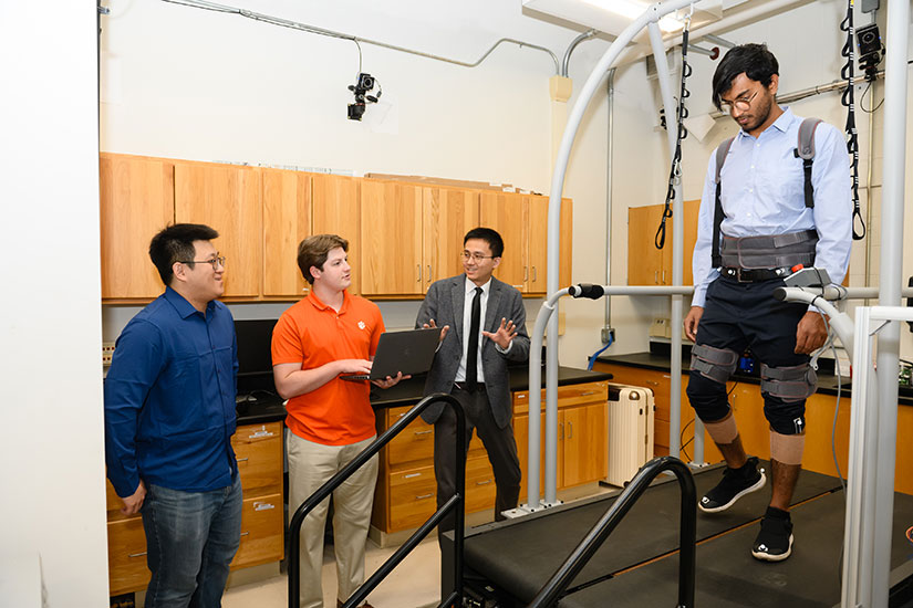 Ge Lv in research lab, assisted by faculty and students