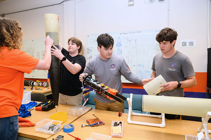 Student adding components inside of rocket they are building