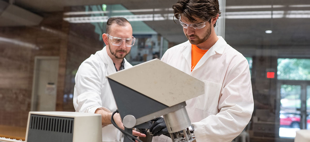 Two graduate students in lab preparing for Paris Air Show