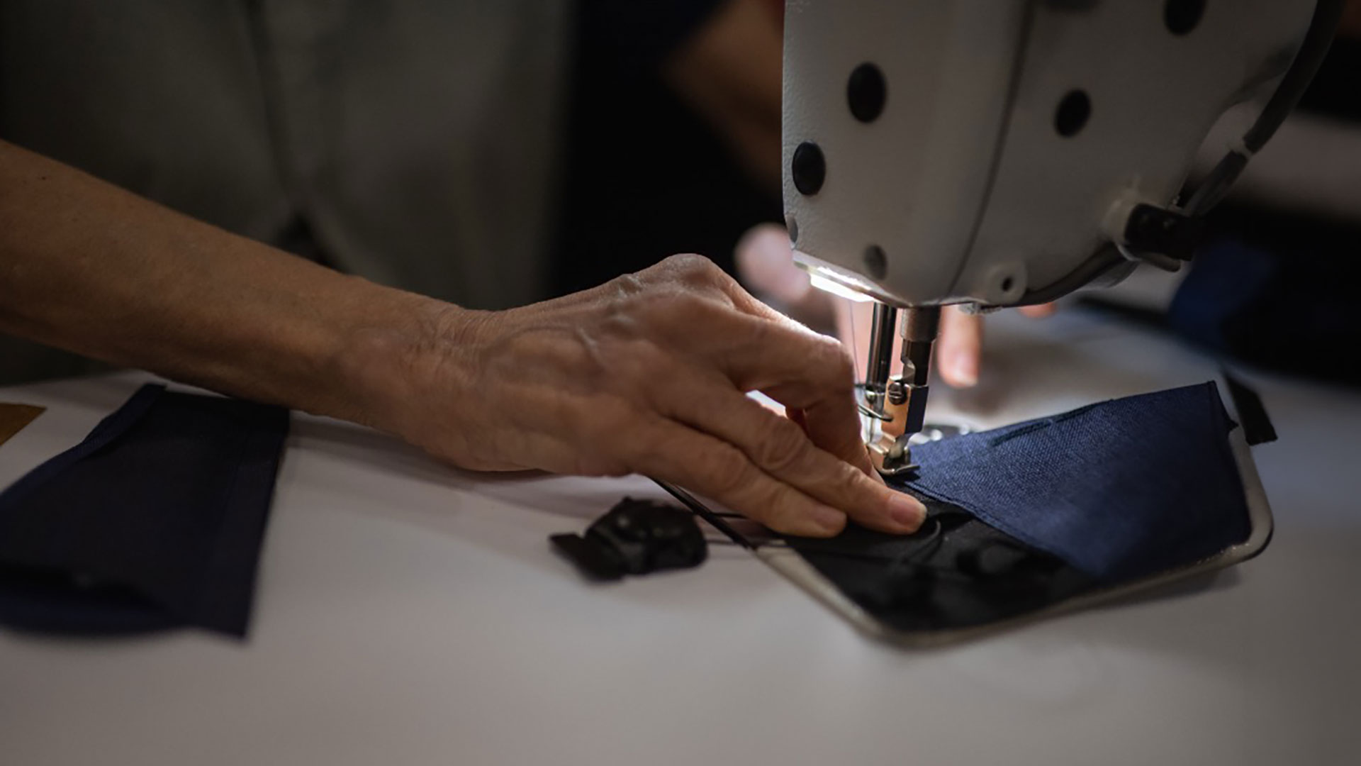 Thigh cuff being sewn on machine in spot light