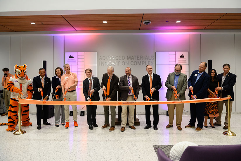 Ribbon cutting ceremony at AMIC, using Clemson Textiles-created ribbon.