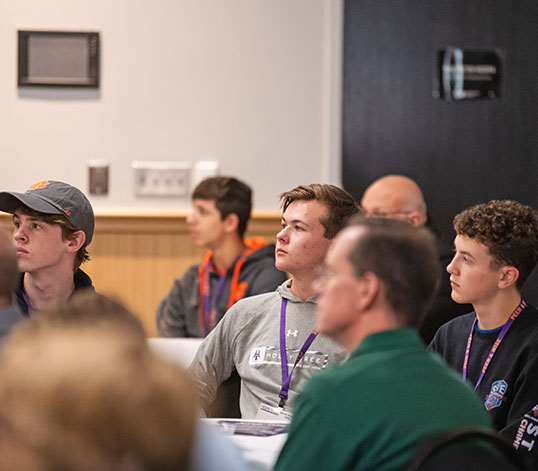 Students and their parents at a session listening intently.