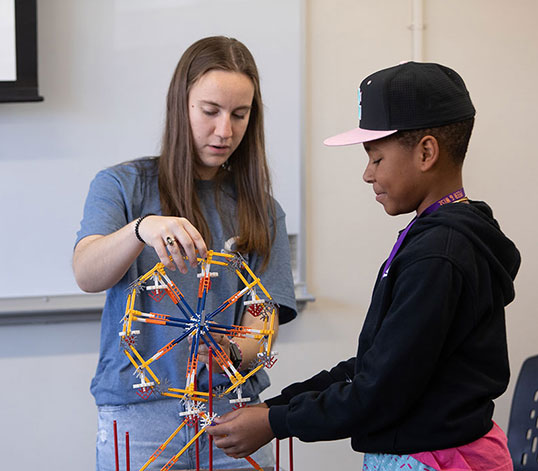 Student and assistant holding a wheel built in class