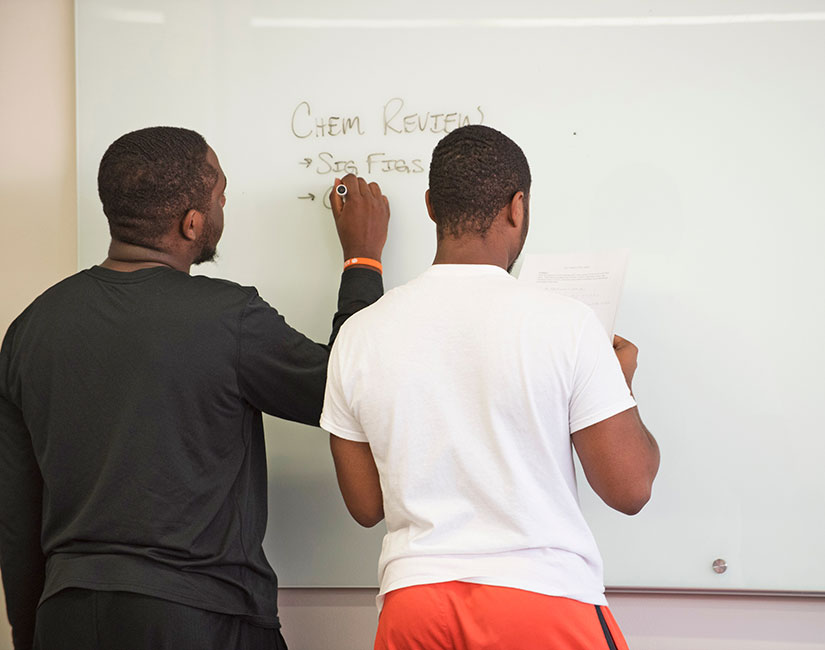 Two students at board in study hall