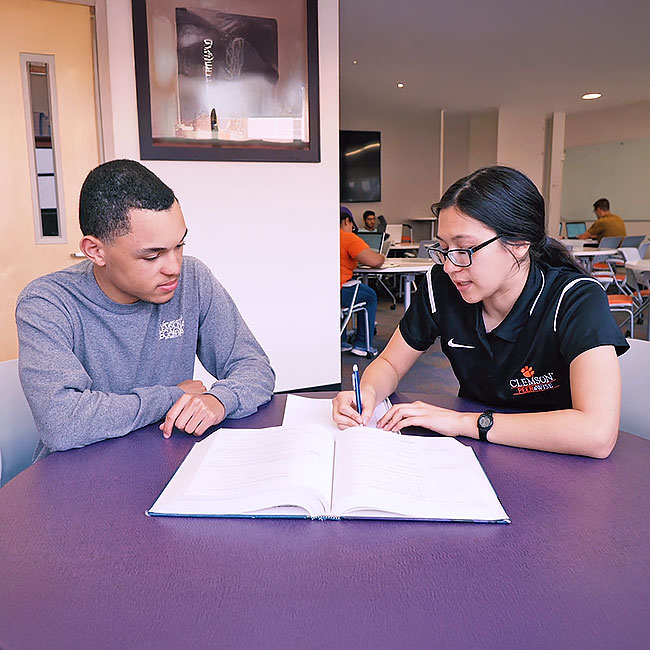 Students helping other student with studies