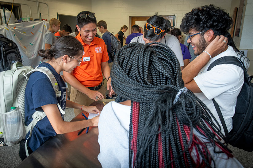 Group of students standing together laughing with teacher