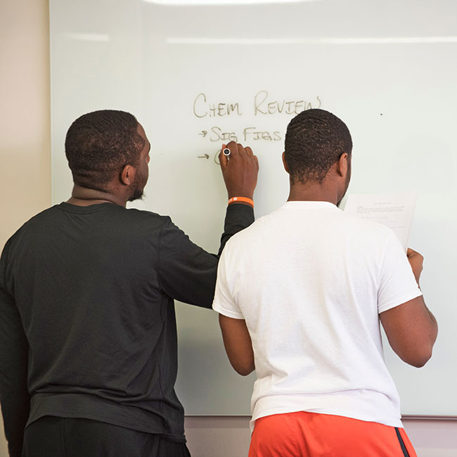 Two students at board in study hall
