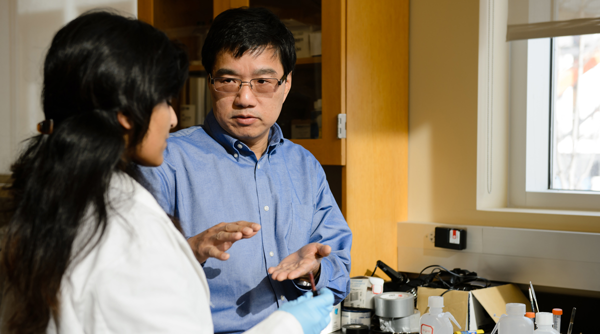 Researcher and student in lab