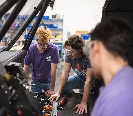 Students in Automotive Engineering program working on vehicle interior.