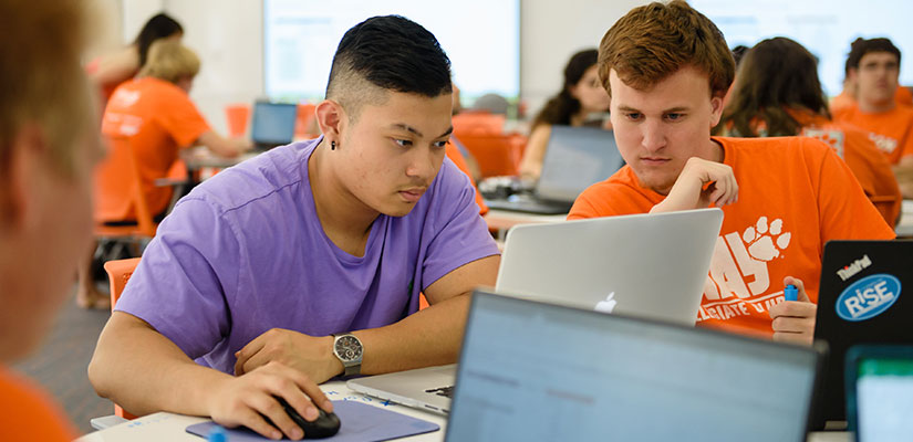 Students in class working on laptop together