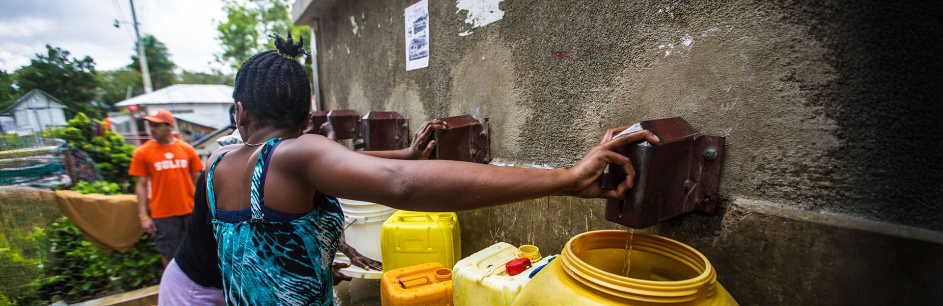 Woman filling a water jug after a successful project