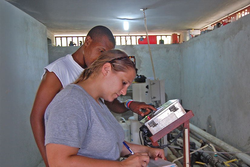 Two students writing down data they've collected on site