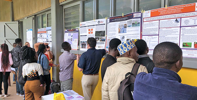 Clemson posters on the wall of the technical school with a group looking over the data.