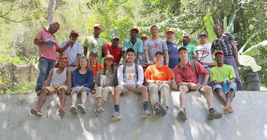 Cange Water Team group sitting on wall together