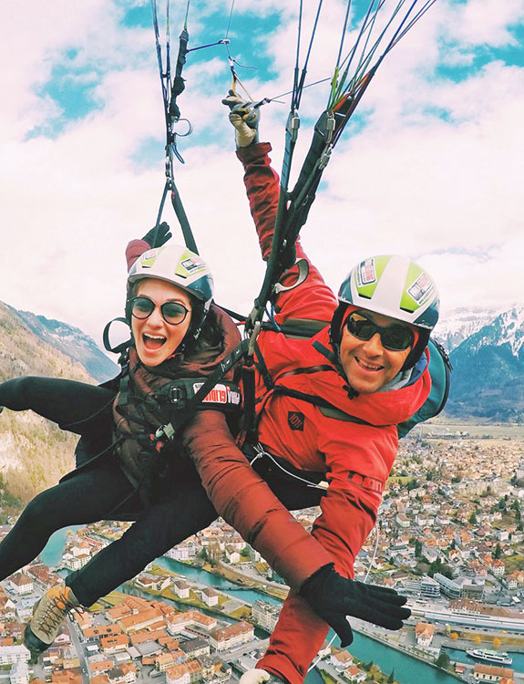 Two people in air above mountains.