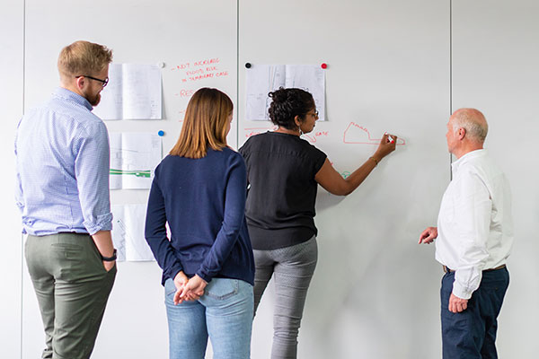 People writing on whiteboard